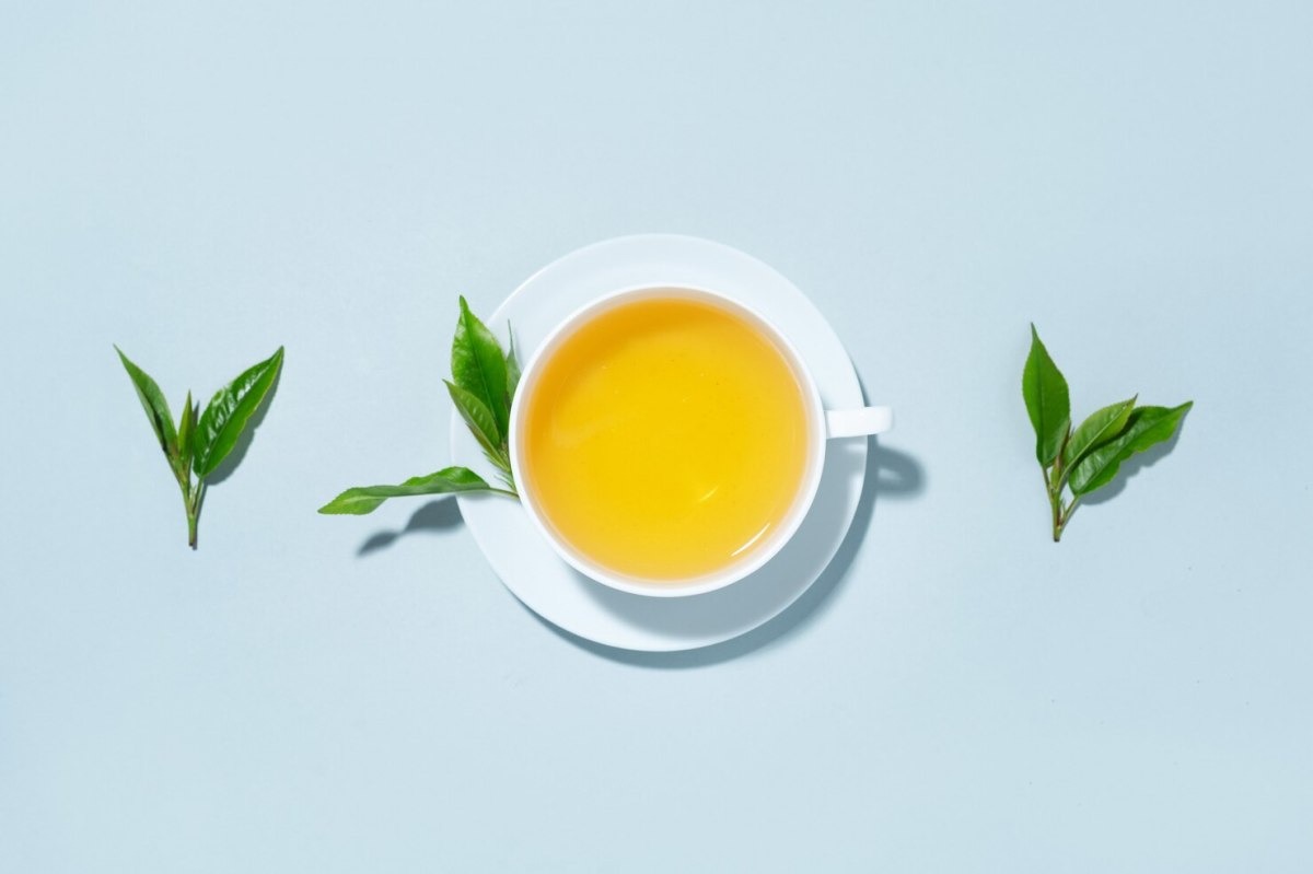 green tea brewed cup with tea leaf